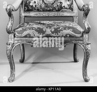 Ein französischer Sessel (Fauteuil) aus dem ersten Viertel des 18. Jahrhunderts, geschnitztes und vergoldetes Buchenholz mit Wolle Aubusson Wandteppichen, 47 1/2 x 27 1/2 x 21 5/8 cm, Teil der MET-Sammlung, repräsentativ für die französische dekorative Kunst und Möbelkunst des 18. Jahrhunderts. Stockfoto