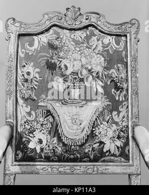 Ein französischer Sessel (Fauteuil) aus dem ersten Viertel des 18. Jahrhunderts, geschnitztes und vergoldetes Buchenholz mit Wollbezügen aus Aubusson, 47 1/2 x 27 1/2 x 21 5/8 cm, Teil der MET-Kollektion, beispielhaft für Möbeldesign und Handwerkskunst der Zeit. Stockfoto