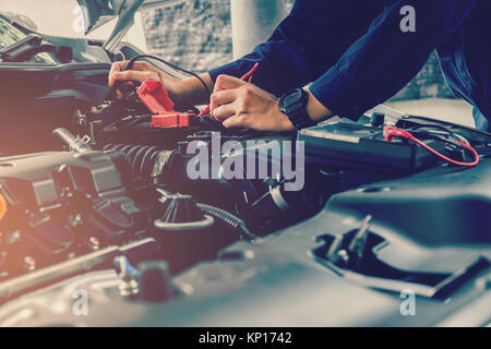 Automechaniker auto Batteriespannung prüfen Stockfoto