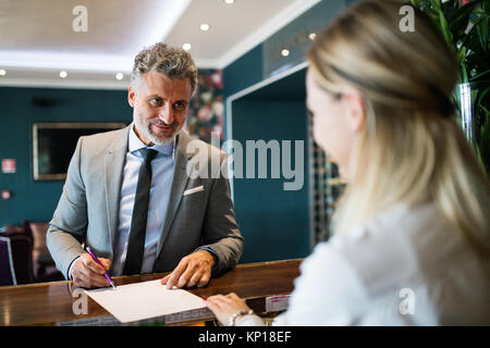 Reifen Geschäftsmann an der Hotelrezeption. Stockfoto