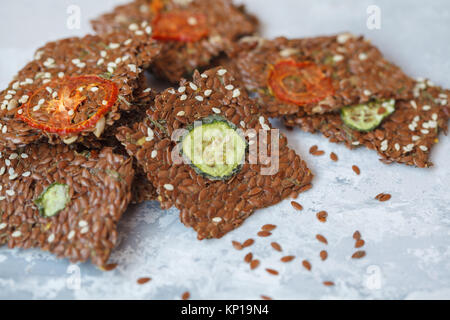 Knackiges Gemüse Flachs Knäckebrot mit Sesam und Kräutern. Gesunden veganen Snack mit Leinsamen, Sesam und Gemüse Schichten. Stockfoto