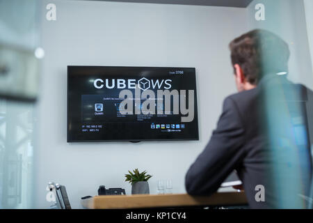 Ansicht der Rückseite des Geschäftsmann Fernsehen im Büro Stockfoto