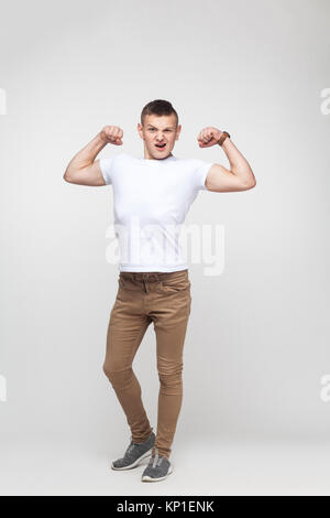 Happines Junge, Männlichkeit und seine Kamera stark. Innen- schuss, grauer Hintergrund Stockfoto