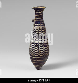 Diese Glasalabastron ist eine antike Parfümflasche, die Gefäßdesign und Handwerkskunst veranschaulicht und in einer Museumssammlung aufbewahrt wird. Stockfoto