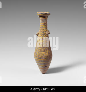 Eine antike Alabastron-Parfümflasche aus Glas, die die Handwerkskunst und das Design der Gefäße veranschaulicht, die in einer Museumssammlung aufbewahrt wird. Stockfoto