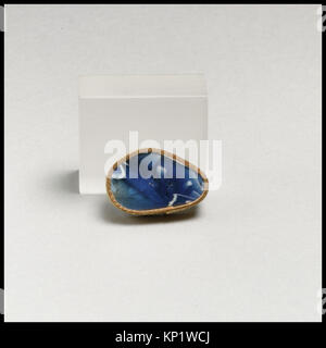 Dieses gerippte Schälfragment aus römischem Glasmosaik aus dem späten 1. Jahrhundert v. Chr. bis zum frühen 1. Jahrhundert n. Chr. zeigt ein durchscheinendes Kobaltblau und ein opakes weißes Band-Mosaikmuster. Die leicht konvex gewölbte Seite verjüngt sich nach unten, und das Äußere zeigt einen Teil von vier vertikalen Rippen mit abgerundeten Außenseiten, die sich nach unten verjüngen. Stockfoto