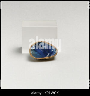 Dieses gerippte Schälfragment aus römischem Glasmosaik aus dem späten 1. Jahrhundert v. Chr. bis zum frühen 1. Jahrhundert n. Chr. zeigt ein durchscheinendes Kobaltblau und ein opakes weißes Band-Mosaikmuster. Die leicht konvex gewölbte Seite verjüngt sich nach unten, und das Äußere zeigt einen Teil von vier vertikalen Rippen mit abgerundeten Außenseiten, die sich nach unten verjüngen. Stockfoto