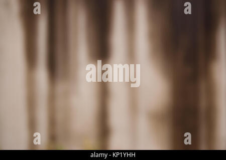 Defokussierten Betonwand mit schlechtem Wetter mit vertikalen braune Streifen bedeckt. verwischt. Stockfoto