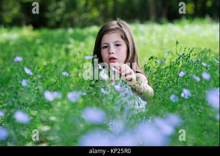 Kleines Mädchen in einem Flachs Feld Blüte, Center-Val de Loire Region, Frankreich und Europa.