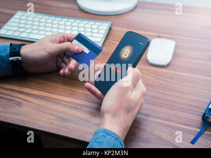 Hände, die Kreditkarte und Telefon. bitcoin online kaufen Stockfoto