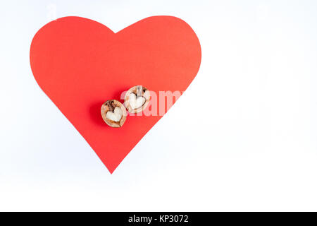 Rotes Herz aus Papier und die beiden Hälften des Nussbaum in Form von Herzen auf Sie auf weißem Hintergrund mit kopieren. Stockfoto