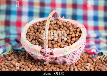 Rosa Korb voller Haselnuss Stockfoto