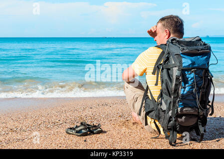 Reisende mit einem Rucksack auf dem Strand in der Nähe des Meeres in Thailand Stockfoto