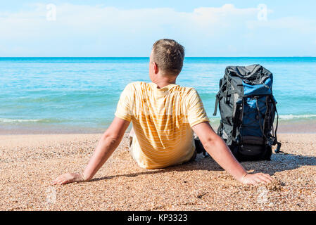 Fit Tourist mit einem Rucksack in der Nähe von dem Meer auf den Strand Stockfoto