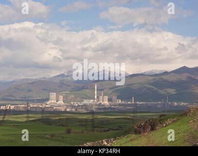 Landschaft und Bergpanorama von der Hauptstraße zwischen Eriwan und Sevan See in Armenien, der, Idylle durch eine Zementfabrik gestört gesehen Stockfoto