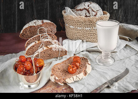 Schönen Laib Brot aus weißem Weizen auf einem Schild auf einer Leinwand. Sie hausgemachte Kuchen mit hausgemachten Apple Marmelade. In einem rustikalen Stil
