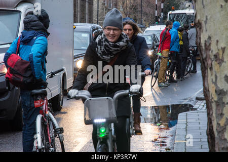 London, England, Großbritannien - 13 Dezember, 2017: Aktivisten machen eine "menschliche-geschützten Radweg für Radfahrer in einem Appell für eine bessere Infrastruktur für Wandern und Radfahren auf Penton Street, einen Transport for London" Quietway" in Islington, London. Stockfoto