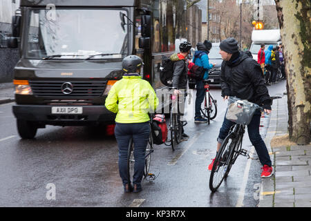 London, England, Großbritannien - 13 Dezember, 2017: Aktivisten machen eine "menschliche-geschützten Radweg für Radfahrer in einem Appell für eine bessere Infrastruktur für Wandern und Radfahren auf Penton Street, einen Transport for London" Quietway" in Islington, London. Stockfoto