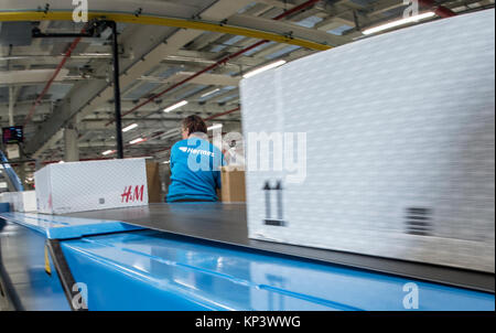 Ketzin, Deutschland. 13 Dez, 2017. Ein Mitarbeiter arbeitet an einem Förderband mit Pakete in das neue Hermes Logistik in Ketzin, Deutschland, 13. Dezember 2017. Das Unternehmen plant auf Triple seine Kapazitäten im Großraum Berlin mit dem neuen Zentrum. Bis zu 250.000 Pakete können in der 80.000 Quadratmeter großen Gebäude verarbeitet werden. Die Lieferzeiten sind sagte zurückgehen, während 200 Arbeitsplätze geschaffen werden. Credit: Paul Zinken/dpa/ZB/dpa/Alamy leben Nachrichten Stockfoto