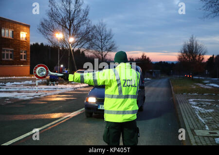 Schönberg, Deutschland. 13 Dez, 2017. Einen Zollbeamten stoppt ein Auto am ehemaligen Grenzübergang Deutschland/Tschechien in der Nähe von Schönberg, Deutschland, 13. Dezember 2017. Vor allem die Bekämpfung der Kriminalität im Zusammenhang mit Betäubungsmitteln ist einer der Schwerpunkte in der Zusammenarbeit zwischen den regionalen Polizei Verzeichnis Karlovy Vary (Tschechien) im Rahmen eines gemeinsamen EU-Projekt. Achtung Redaktionen: License Plate pixelised Für Persönlichkeit gründen. Credit: Bodo Schackow/dpa-Zentralbild/dpa/Alamy leben Nachrichten Stockfoto