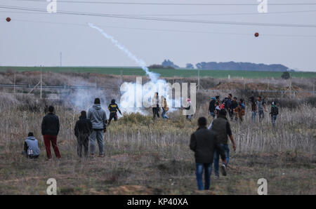 Gaza, Gazastreifen. 13 Dez, 2017. Palästinensische Demonstranten zurück werfen ein tränengas Kanister von israelischen Sicherheitskräften bei Zusammenstößen in der Nähe der Grenze Israel-Gaza abgefeuert, als Palästinenser protestieren gegen die Entscheidung des US-Präsidenten Trump Jerusalem als Hauptstadt von Israel zu erkennen, östlich von Gaza, Gazastreifen, 13. Dezember 2017. Credit: Wissam Nassar/dpa/Alamy leben Nachrichten Stockfoto