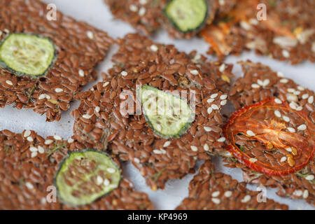 Knackiges Gemüse Flachs Knäckebrot mit Sesam und Kräutern. Gesunden veganen Snack mit Leinsamen, Sesam und Gemüse Schichten. Stockfoto