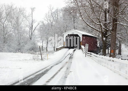 Schneit an eine überdachte Brücke in Lancaster County, Pennsylvania, USA. Stockfoto