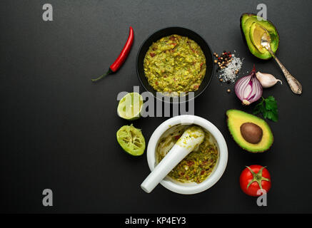 Frische Zutaten mit Avocado für Guacamole Sauce auf schwarzem Hintergrund Stockfoto