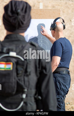 Eine italienische Carabineri Trainer beauftragt eine asayish Mitglied während der polizeilichen Ausbildung in der Kurdistan Training Coordination Center, östlich von Erbil, Irak: 23. Oktober 2017. Die KTCC ist ein Combined Joint Task Force - inhärenten Building Partner Kapazität beheben Standort Training Partner Kräfte und Verstärkung ihrer Wirksamkeit auf dem Schlachtfeld gewidmet. CJTF-OIR ist die globale Koalition zu besiegen ISIS im Irak und in Syrien. (U.S. Armee Stockfoto