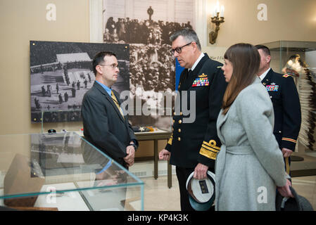 Tim Frank (links), Historiker, Arlington National Cemetery bietet eine Führung durch die Gedenkstätte Amphitheater Anzeige Zimmer zum stellvertretenden Leiter der Australian Defence Force, Vice Adm. Ray Griggs (Mitte), und sein Ehegatte, Chloe (rechts), auf dem Arlington National Cemetery, Arlington, Virginia, Dez. 7, 2017. Griggs teilgenommen haben früher in einem bewaffneten Kräfte die volle ehrt Wreath-Laying Zeremonie am Grab des Unbekannten Soldaten. (U.S. Armee Stockfoto