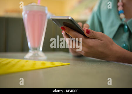 Nahaufnahme der Frau im Restaurant sitzen können Sie über Ihr Mobiltelefon Stockfoto