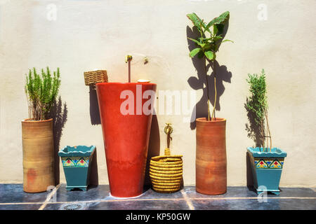 Deco Waschbecken und Pflanzen gegen eine Wand in einem mediterranen Land. Stockfoto