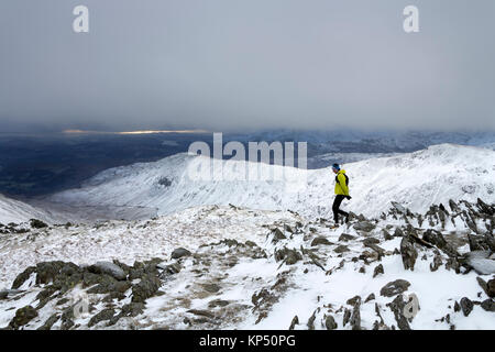 Runner Abstieg vom Gipfel des Hart-Crag auf taube Crag im Winter, mit Blick über die South West Rydal Fells, Lake District, C Stockfoto