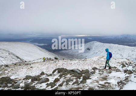 Wanderer Abstieg vom Gipfel des Hart-Crag auf taube Crag im Winter, mit Blick über die South West Rydal Fells, Lake District, Stockfoto