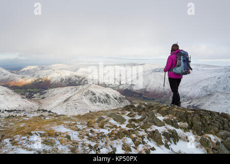 Wanderer auf dem Gipfel des Hart-Crag im Winter, mit Blick auf die östlichen Berge, Lake District, Cumbria, Großbritannien Stockfoto