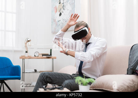 Geschäftsmann gestikulierend und mit Virtual reality Headset Stockfoto