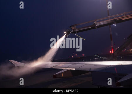 Entfroster Flügel vor dem Flug im Winter. Flughafen in die eisige Kälte im Winter. Entfrosterschalter des Flugzeugs vor dem Flug. Stockfoto