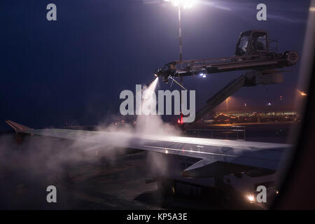 Entfroster Flügel vor dem Flug im Winter. Flughafen in die eisige Kälte im Winter. Entfrosterschalter des Flugzeugs vor dem Flug. Stockfoto