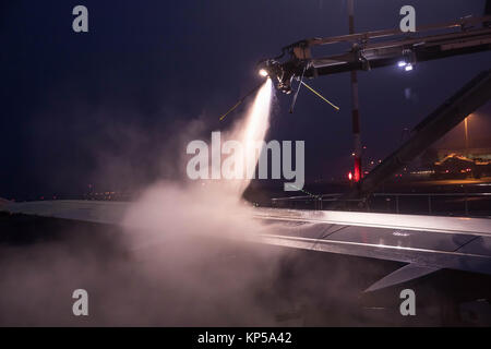 Entfroster Flügel vor dem Flug im Winter. Flughafen in die eisige Kälte im Winter. Entfrosterschalter des Flugzeugs vor dem Flug. Stockfoto