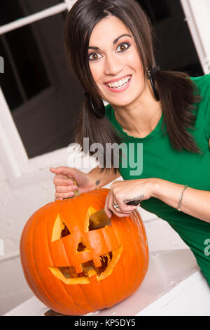 Aufgeregt, glückliche Frau Schneiden schnitzen Halloween Kürbis Jack-O-Lantern Stockfoto