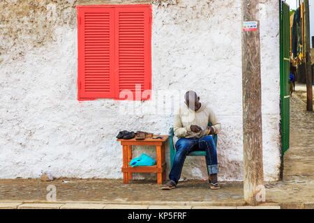 Lokaler Mann arbeitet als Schuster in den Gassen von Santa Maria, Insel Sal, Sal, Kap Verde, Afrika Stockfoto