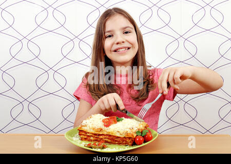 Hungrige kleine Mädchen essen lazagne Stockfoto