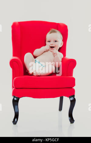 Baby, 4 Monate, Sitzt Auf Einem Roten Stuhl - Baby sitzend auf einem roten Stuhl Stockfoto