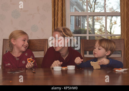 Mutter mit 2 Kinder dekorieren Kekse Stockfoto