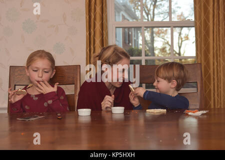 Mutter mit 2 Kinder dekorieren Kekse Stockfoto