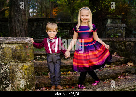 Bruder und Schwester stehen zusammen draußen in öffentlichen Park in formelle Kleidung Stockfoto