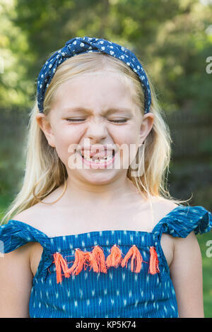 Adorable Schule Alter Mädchen zeigt fehlende vordere zwei Baby Zähne Stockfoto