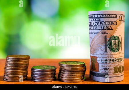 Einhundert US-Dollar Banknoten Banknoten, mit amerikanischen Cent Münzen auf grünem Hintergrund verschwommen Bokeh. Stockfoto