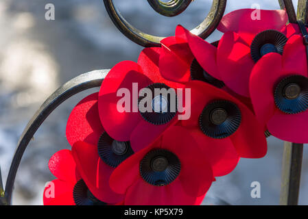 Ein Kranz von Mohnblumen auf einem Denkmal Tor flattern im Wind. Stockfoto