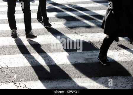 Schatten und Silhouetten, die Überquerung der Straße im Winter in Schwarz und Weiß Stockfoto